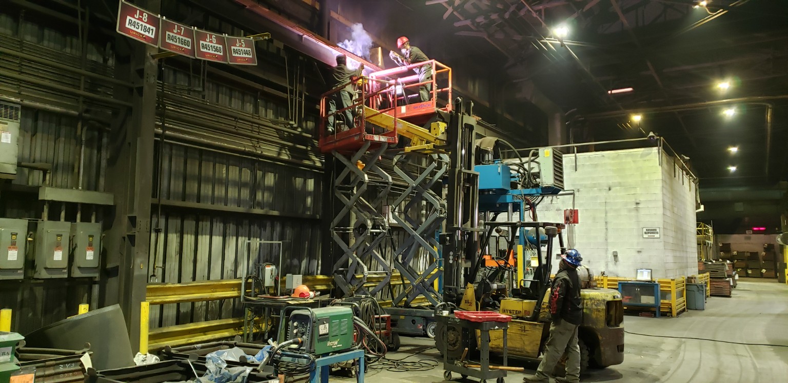 Industrial hot work crew on a scissor lift in a high-consequence environment